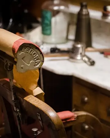 Una silla de barbero clásica junto a un tocador de mármol